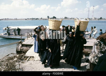 Suez Canal, Egypt - 1981 - Before the construction of the first tunnel under the Suez Canal, by the British, to be named the Ahmed Hamdi Tunnel, all passenger and vehicle traffic from Africa to Asia (Egypt to Sinai) had to cross by ferry, a slow and time consuming method.  The Suez Canal is one of the marvels of engineering constructed in 1869 by Frenchman Ferdinand de Lesseps, it is today undergoing a signficant upgrade by adding a parallel canal to increase two-way shipping traffic and lessen waiting times. Stock Photo