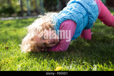 Portrait of cute blonde little girl playing outdoors Stock Photo