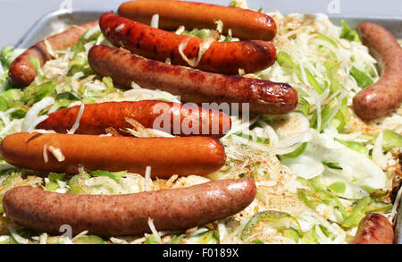 Juicy grilled sausages on vegetables Stock Photo