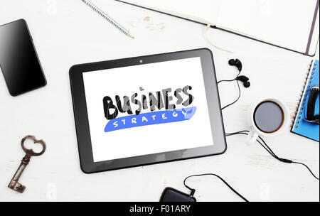 Business strategy. Digital tablet with "Business strategy" lettering on screen. Stock Photo