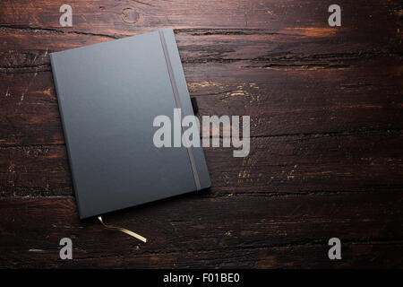 Notepad laying on a old dark wooden table Stock Photo