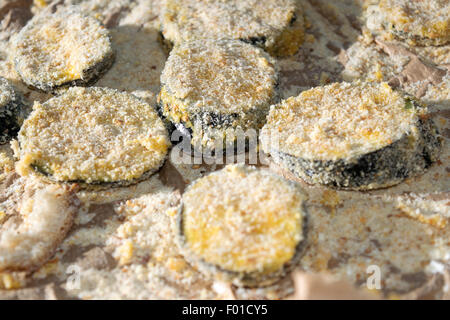 slices of breaded eggplants ready to be fried Stock Photo