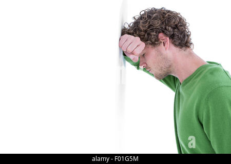 Sad casual man leaning against wall Stock Photo