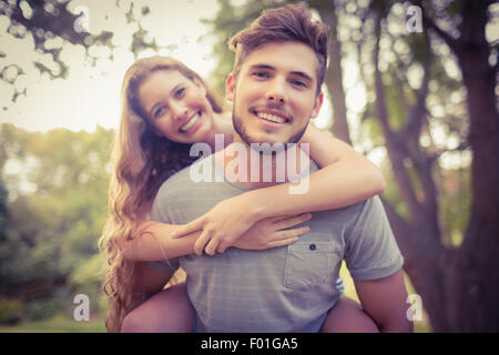 Handsome man giving piggy back to his girlfriend Stock Photo