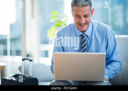 Happy businessman using laptop computer Stock Photo