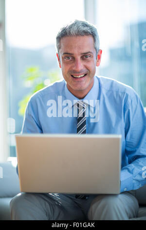 Happy businessman using laptop computer Stock Photo