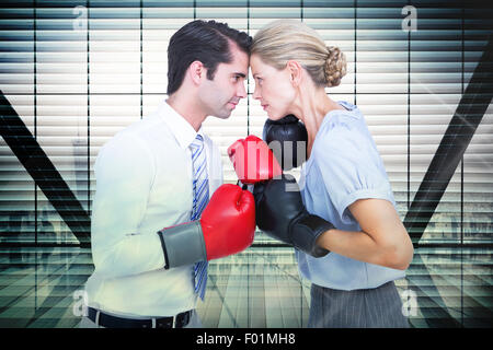 Composite image of business people wearing and boxing red gloves Stock Photo