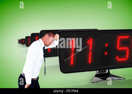Composite image of worried businessman leaning on wall Stock Photo
