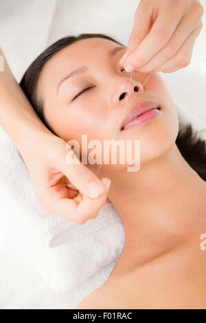 Hands threading beautiful womans face Stock Photo