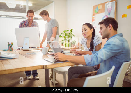 Creative business team gathered around laptops Stock Photo
