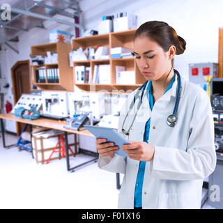 Composite image of young doctor standing with tablet pc Stock Photo