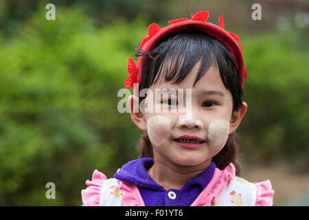 Local girl with a red cap and Thanaka paste on her face, portrait, Yangon, Myanmar Stock Photo