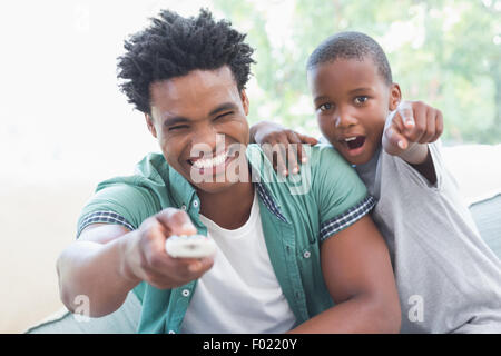 Father and son watching tv together on the couch Stock Photo