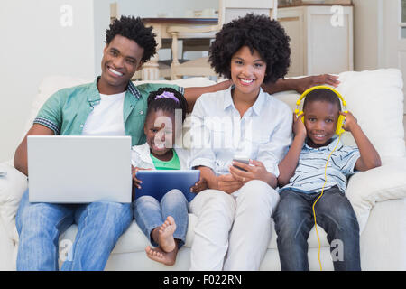 Happy family using technologies on the couch Stock Photo