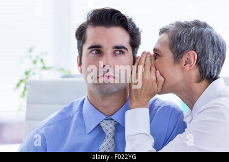 Two business people looking at a paper while working on folder Stock Photo