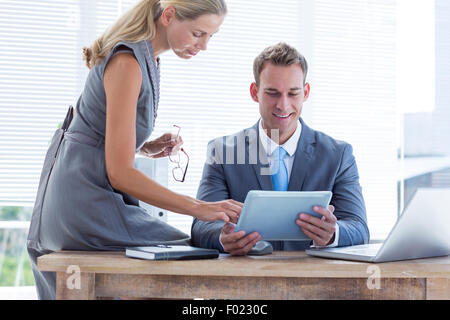 Happy colleagues working together on tablet Stock Photo
