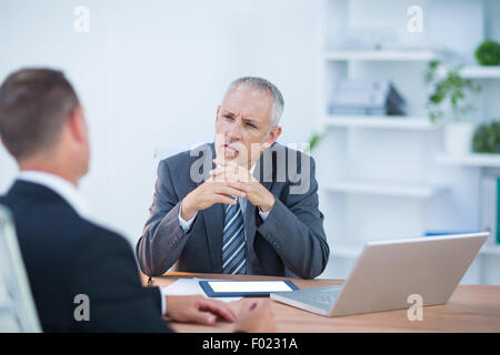 Serious colleagues working together on laptop and digital tablet Stock Photo