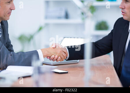 Two businessmen shaking hands and working Stock Photo