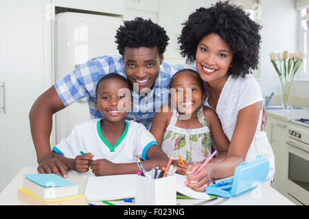 Happy parents helping children with homework Stock Photo