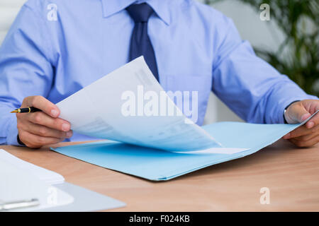 Businessman reading a contract before signing it Stock Photo
