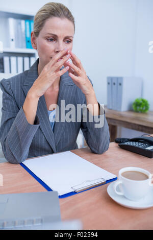 Pretty blonde businesswoman thinking Stock Photo