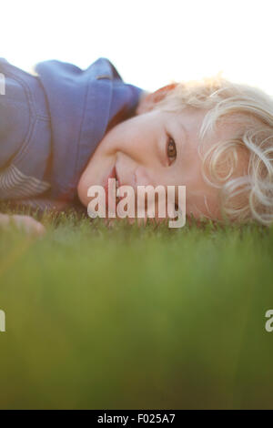 Portrait of a Boy lying on the grass Stock Photo