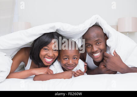 Portrait pretty couple with his son in bed together Stock Photo