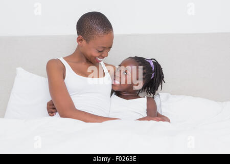 Pretty beautiful mother with her daughter in her bed Stock Photo