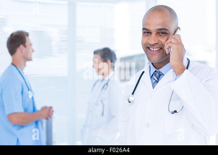 Smiling doctor talking on the phone Stock Photo