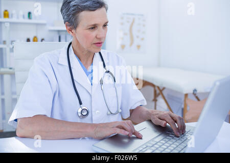 Serious female doctor using her laptop computer Stock Photo