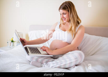 Pregnant woman using laptop computer Stock Photo
