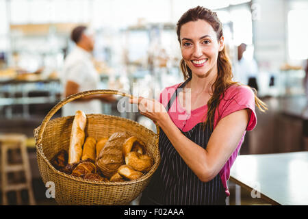Pretty waitress carrying basket of bread Stock Photo