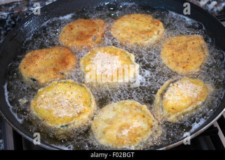 slices of breaded eggplants during the fry in a pan Stock Photo