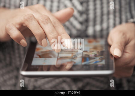 Woman with tablet computer looking digital photos Stock Photo