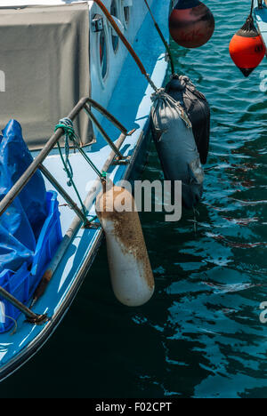 Old buoys hanging on the aboard of fishing boat. Stock Photo