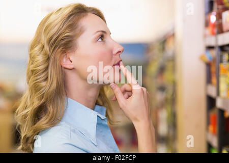 Pretty blonde woman looking at shelves Stock Photo