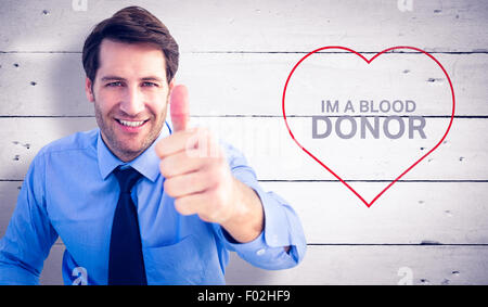 Composite image of smiling businessman gesturing thumbs up Stock Photo