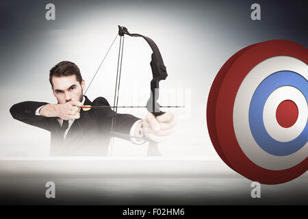 Composite image of smart businessman practicing archery looking at camera Stock Photo