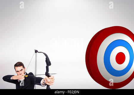 Composite image of smart businessman practicing archery looking at camera Stock Photo