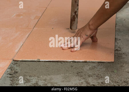 A plasterer is tiling at home, tile floor adhesive renovation at home Stock Photo
