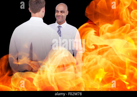 Composite image of businessman holding knife behind his back Stock Photo