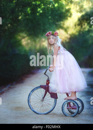 Portrait of a girl standing on the back of a vintage bike, California, USA Stock Photo