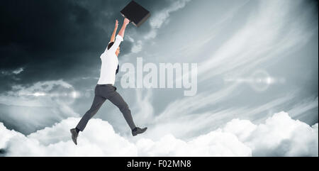 Composite image of businessman leaping with his briefcase Stock Photo