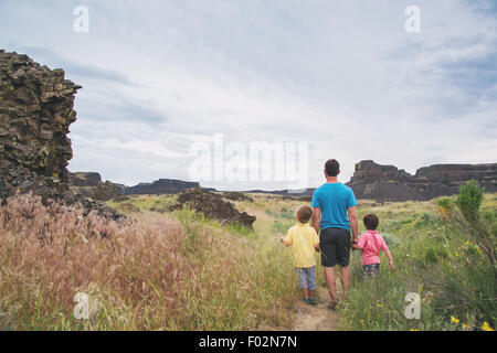 Rear view of father walking with two sons Stock Photo