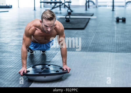 Muscular man doing bosu ball exercises Stock Photo