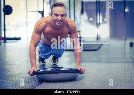 Muscular man doing bosu ball exercises Stock Photo