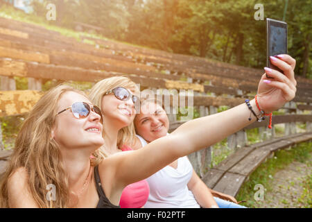 Group of friends taking a selfie with a smartphone outdoors Stock Photo