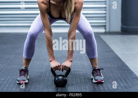 A muscular woman lifting kettlebells Stock Photo