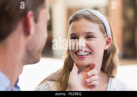 handsome boyfriend touching face of girlfriend with flowers on