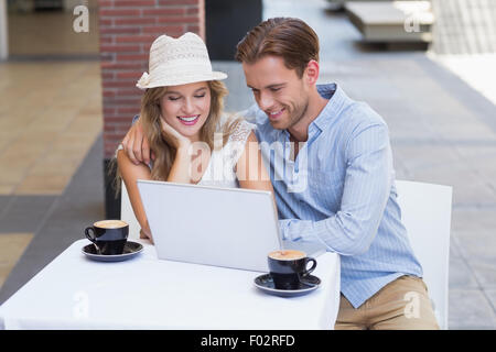 Cute couple looking at a laptop Stock Photo